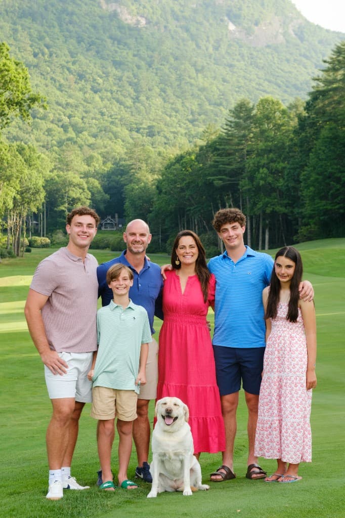 A Panther Pest Control owner with his family and their dog outdoors