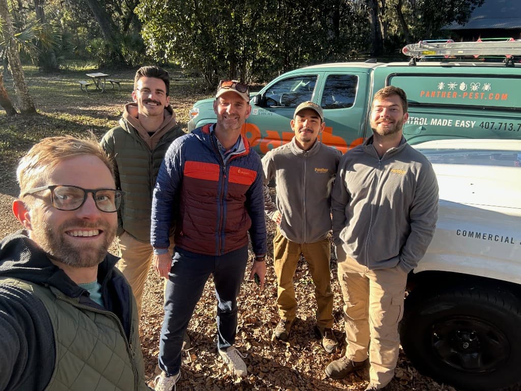 The Panther Pest Control team with their service vans in Central Florida